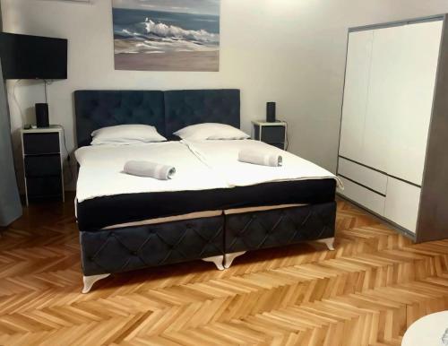 a large bed in a bedroom with a wooden floor at Studio apartman Ivana in Gradište