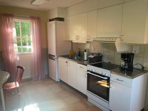 a kitchen with white cabinets and a stove top oven at Valla Vandrarhem in Linköping
