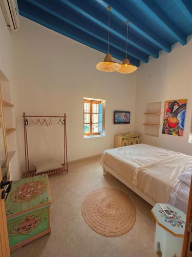 a bedroom with a bed and a blue ceiling at Dar Fattouma in Houmt Souk