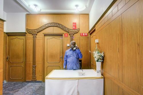 a man taking a picture in front of a table at Hotel O Vivekam Home Stay in Coimbatore
