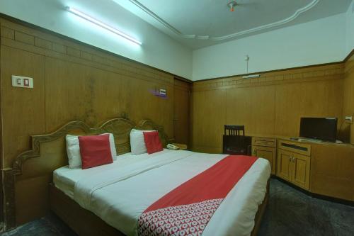 a bedroom with a large bed with red pillows at Hotel O Vivekam Home Stay in Coimbatore