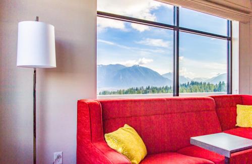 a red couch sitting in front of a large window at Snoqualmie Inn by Hotel America in Snoqualmie