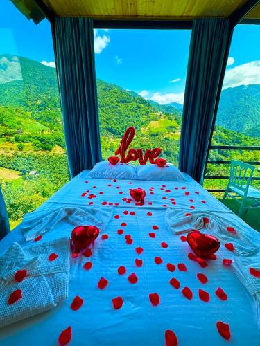 Una cama con corazones rojos frente a una ventana. en Sunrise merisi, en Merisi
