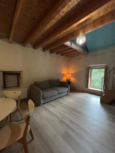 a living room with a couch and a table at Gîte au coeur de la forêt in Saint-Parize-le-Châtel