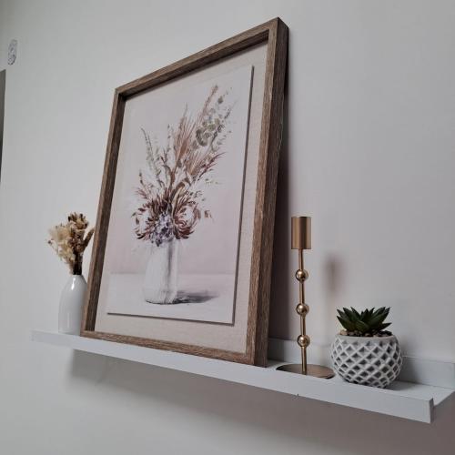 a picture of a vase of flowers on a shelf at Coeur bleu de Ribérac - hyper centre in Ribérac