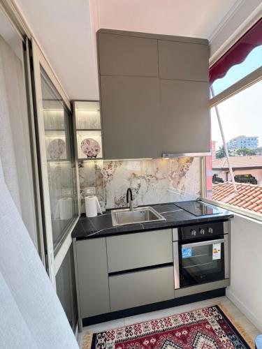 eine kleine Küche mit Spüle und Herd in der Unterkunft Leti Apartment Bazaar Charm in Tirana