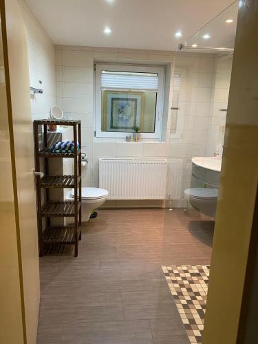 a bathroom with two toilets and a sink and a tub at Ferienwohnung Bergliebe in Füssen