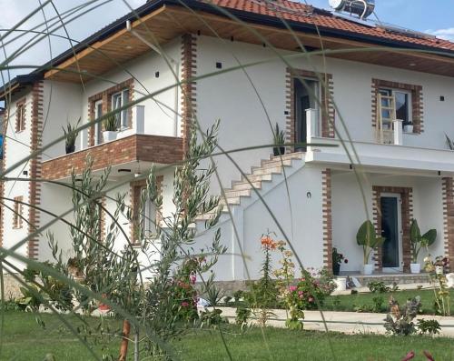 a white house with a balcony on the side of it at Mosaic Guesthouse in Lin