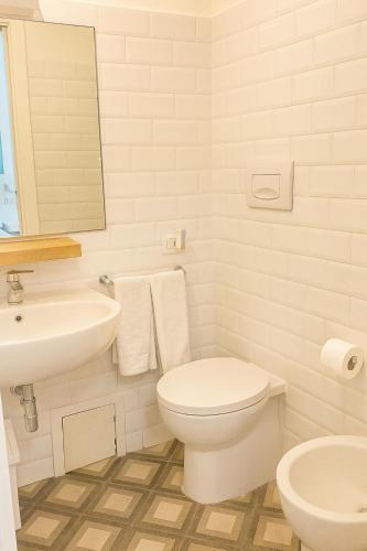 a white bathroom with a toilet and a sink at Guest House S Caterina in Viterbo
