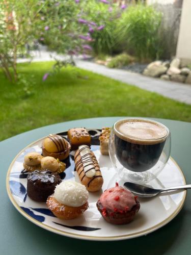 une assiette de beignets et une tasse de café sur une table dans l'établissement Studio romantique avec baignoire balnéothérapie duo et jardin proche de Colmar et Kaysersberg pour 2 personnes, à Lapoutroie