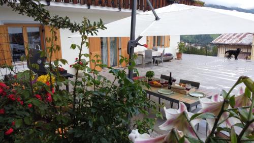 a patio with a table and an umbrella at Posta Apartments in Colle Santa Lucia