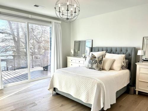 a bedroom with a bed and a large window at Soul Beach Lake House in Chapin