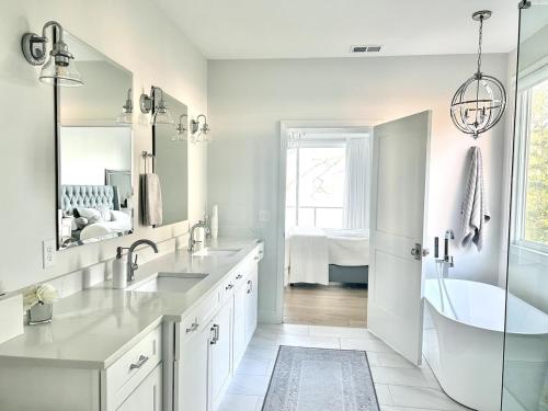 a white bathroom with a tub and a sink at Soul Beach Lake House in Chapin