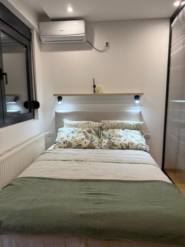 a bedroom with a large bed with avertisementatronatronstrationstration at Studio Crnjanski in Jagodina