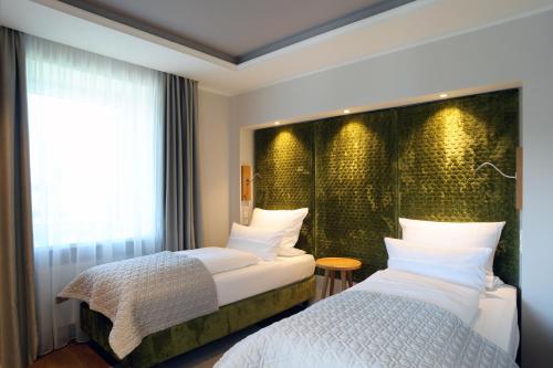 a hotel room with two beds and a window at MICHELS Wellness- & Wohlfühlhotel in Schalkenmehren