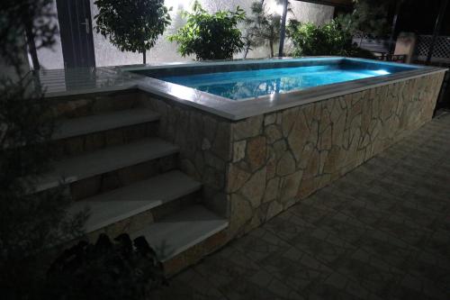 a swimming pool with stairs leading into a house at Lake Retreat Villa in Shkodër