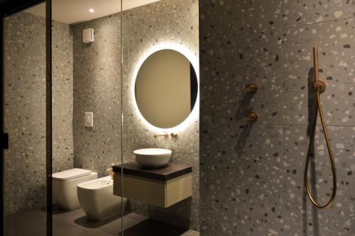 a bathroom with a sink and a toilet and a mirror at Esse Elegant house - B&B dal Design moderno, accoglienza esclusiva in Paganica