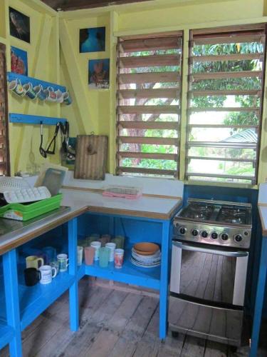 a kitchen with a blue table and a stove at Hotel Chillies and Native Sons Diving in West End