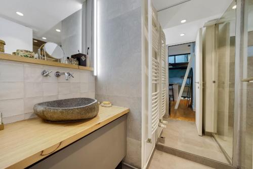 a bathroom with a stone sink on a counter at Secret Loft Paris Zénith in Paris