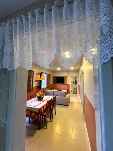 a dining room and living room with a table and chairs at Casa Nona Chema in Bento Gonçalves