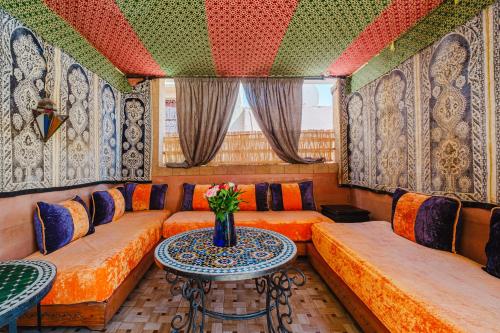 a room with couches and a table with a vase on it at Riad Mazouz102 Médina in Marrakech