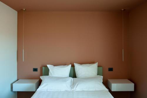 a bedroom with two beds with white pillows at Esse Elegant house - B&B dal Design moderno, accoglienza esclusiva in Paganica