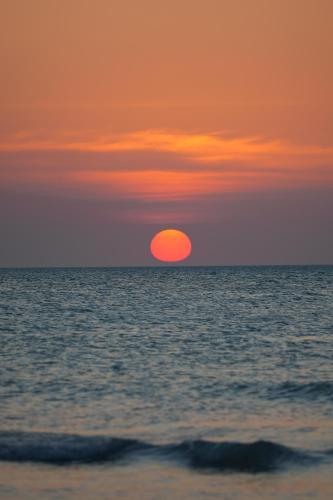 a sunset over the ocean with the sun in the sky at Casa Las Tortugas Petit Beach Hotel & Spa in Holbox Island