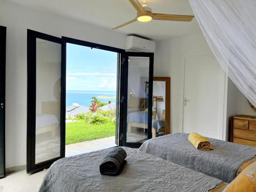 Un dormitorio con dos camas y vista al mar. en Mat'lilet, en Bouillante