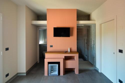 a room with a desk and a tv on a wall at Esse Elegant house - B&B dal Design moderno, accoglienza esclusiva in Paganica