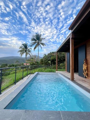 una piscina con vistas a una casa en Mat'lilet, en Bouillante