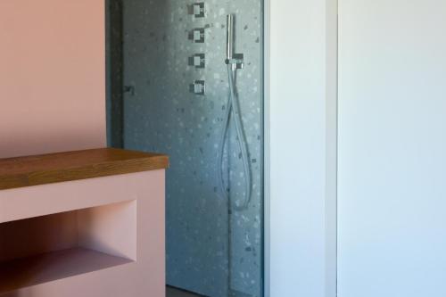 a shower in a bathroom with a blue wall at Esse Elegant house - B&B dal Design moderno, accoglienza esclusiva in Paganica