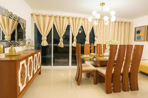 a dining room with a wooden table and chairs at Karamelo Tropical Getaway in Santiago de los Caballeros