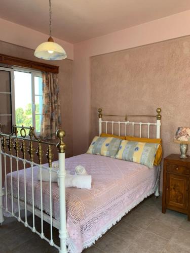 a bedroom with a bed and a window at Αρχόντισσα in Nisís Léros