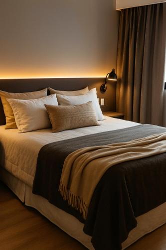 a bedroom with a large bed with white pillows at The Palace Flat Moema 1210 in São Paulo