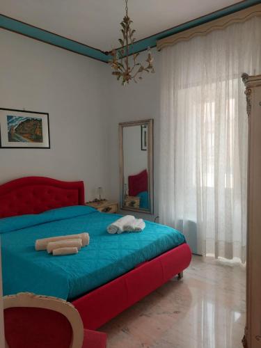 a bedroom with a bed with a blue blanket and a mirror at palazzo sardanelli camera in Pizzo