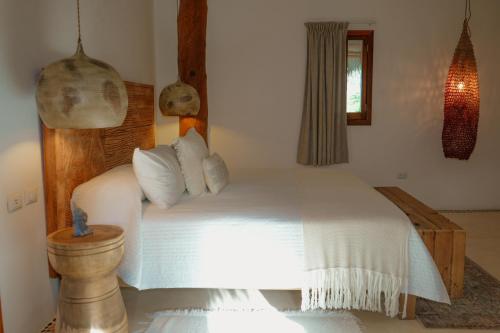 a bedroom with a large white bed in a room at Casa Las Tortugas Petit Beach Hotel & Spa in Holbox Island