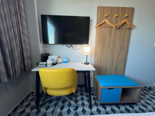 a room with a desk and a yellow chair at Days Inn by Wyndham New York Chinatown in New York