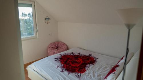 a room with a bed with a bouquet of red roses at SUNSET Villa Apartments in Ohrid