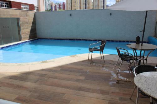 a swimming pool with chairs and tables on a building at Casa Serena in Brasilia