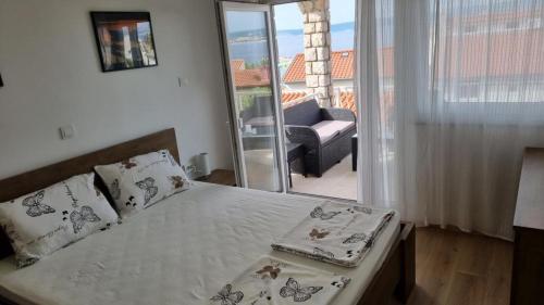 a bedroom with a bed and a balcony with a couch at Damir A4 in Selce