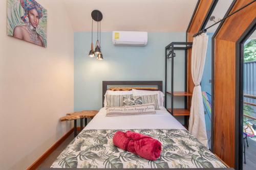 a bedroom with a bed with red pillows on it at Aloki Kire 2 Un oasis moderno cerca del mar Caribe in Talamanca