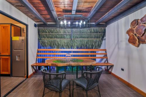 a table and chairs in a room with a painting on the wall at Aloki Kire 2 Un oasis moderno cerca del mar Caribe in Talamanca