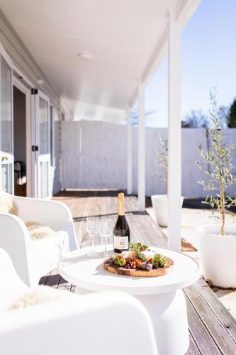 a table with a plate of food and a bottle of wine at Under the Oak in Greytown