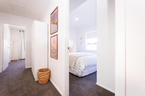 a bedroom with white walls and a bed in a room at Under the Oak in Greytown