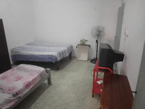 a room with two beds and a tv in it at Alquileres Flavia in Gualeguaychú