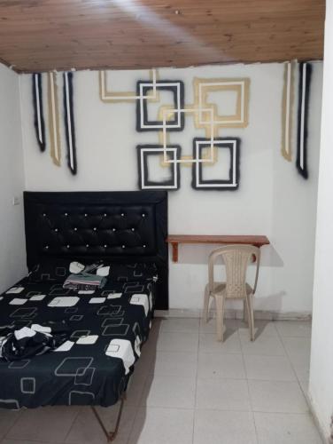 a bedroom with a bed and a table and a chair at Hospedaje los balcones Quilichao in Santander de Quilichao