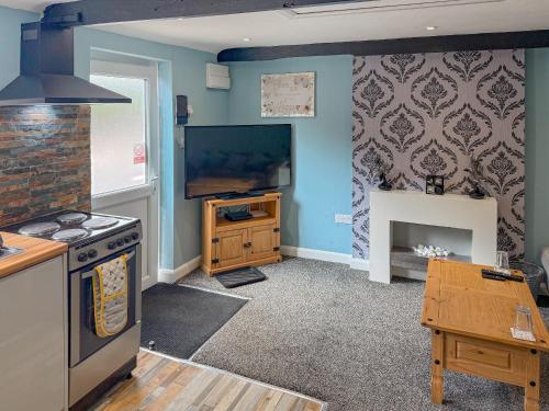 a kitchen with a stove and a tv on the wall at Just Jane's Hangout in Miningsby