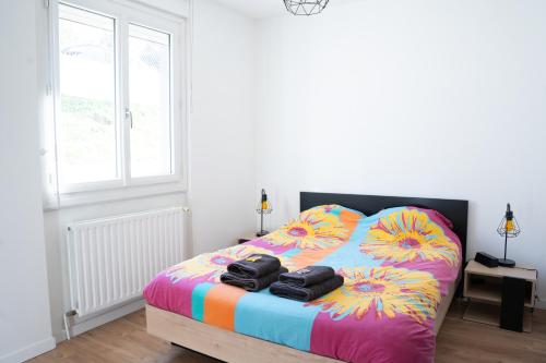 a bedroom with a bed with two towels on it at Maison rayons de soleil in Bagnères-de-Bigorre