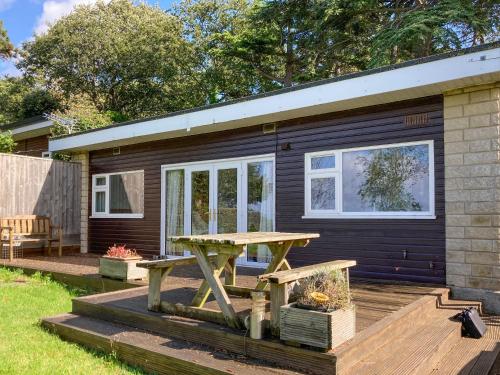 a tiny house with a picnic table on a deck at Exmoor View in Blue Anchor