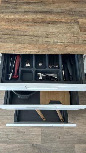 a drawer in a wooden desk with tools in it at Logement 2 pièces propre et calme in Lieusaint